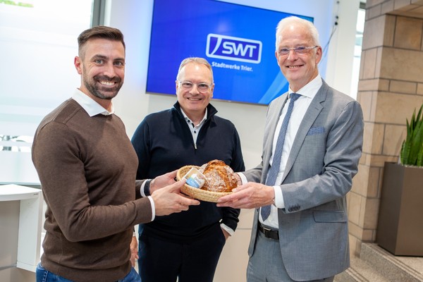Bild: OB Wolfram Leibe heißt SWT-Vorstand Arndt Müller und SWT-Vertriebsleiter Marc Bonertz mit Brot und Salz am neuen Standort willkommen (v.r.n.l.).